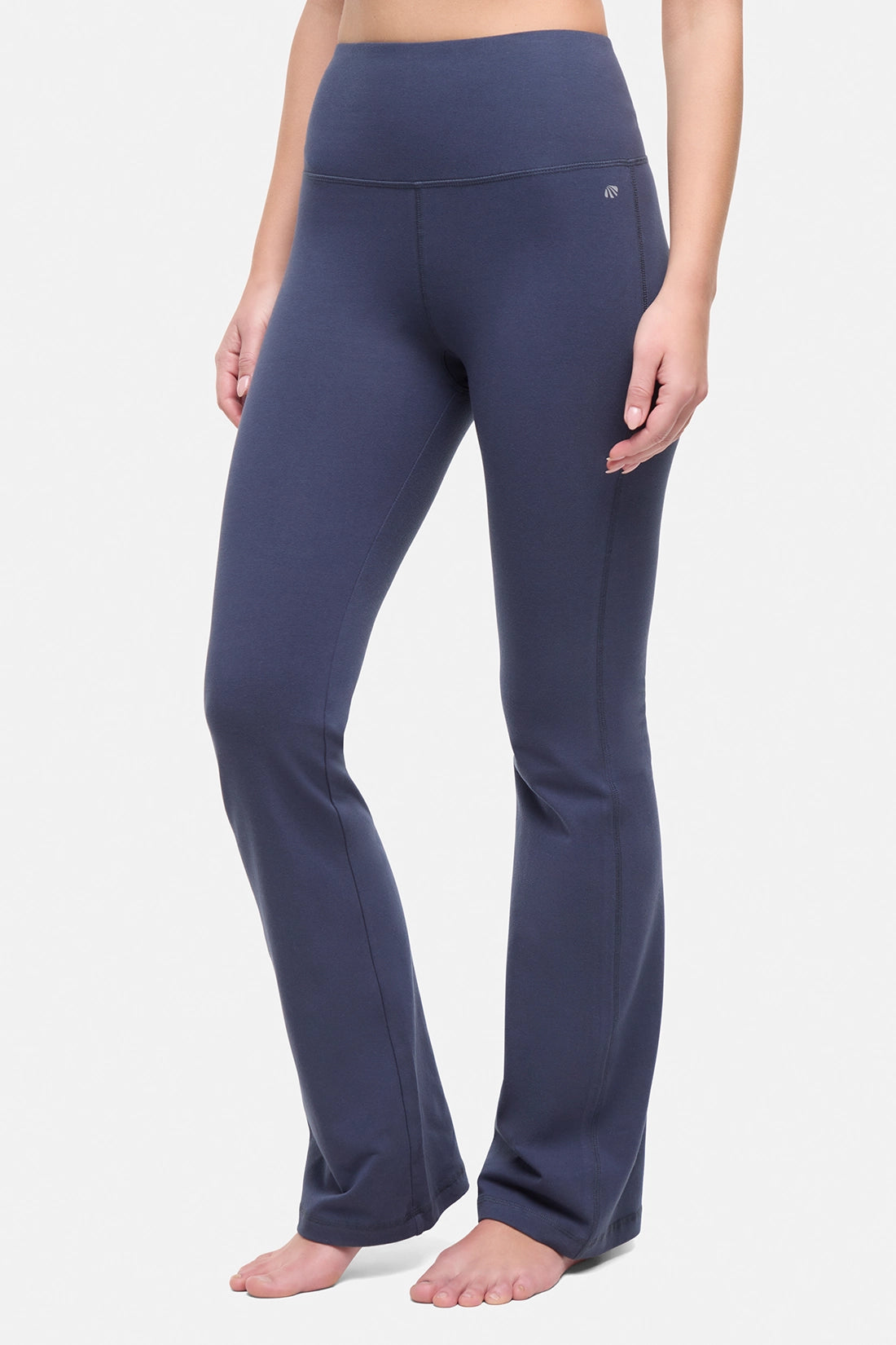Front view of woman wearing navy blue yoga pants on a white background.