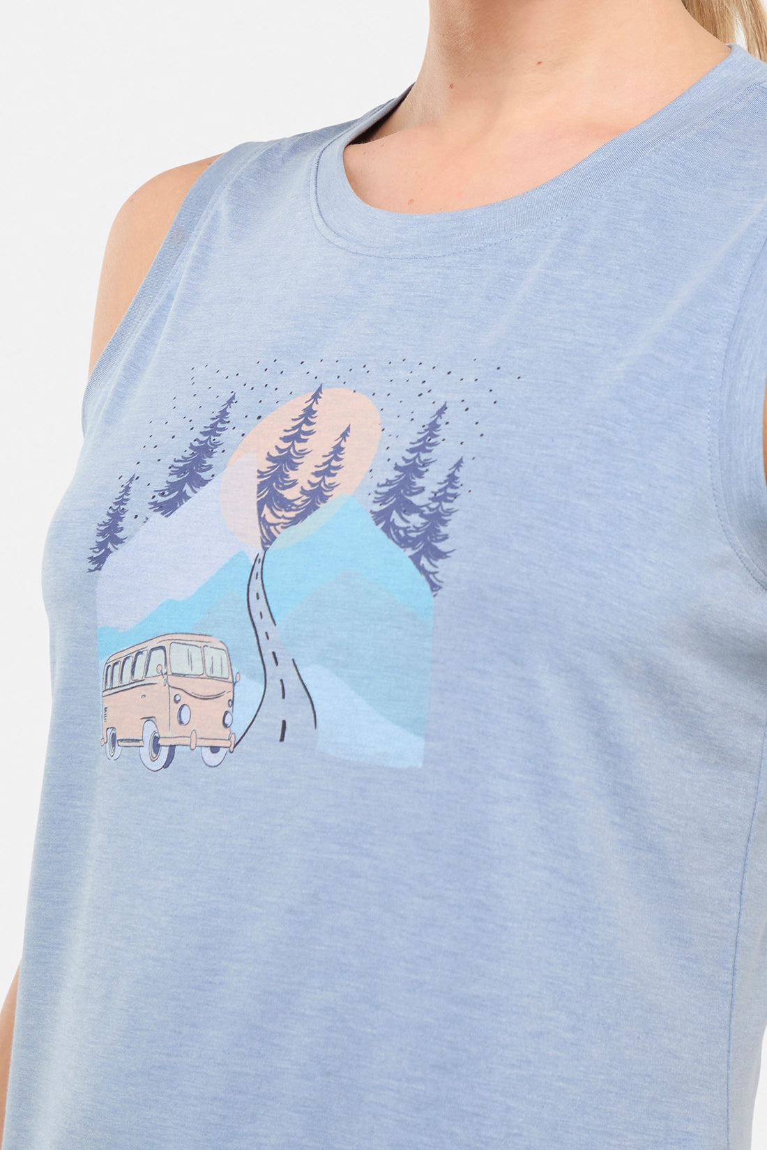 Close up front view of woman wearing a sleeveless light blue shirt with a graphic design of a van and mountains on white background.