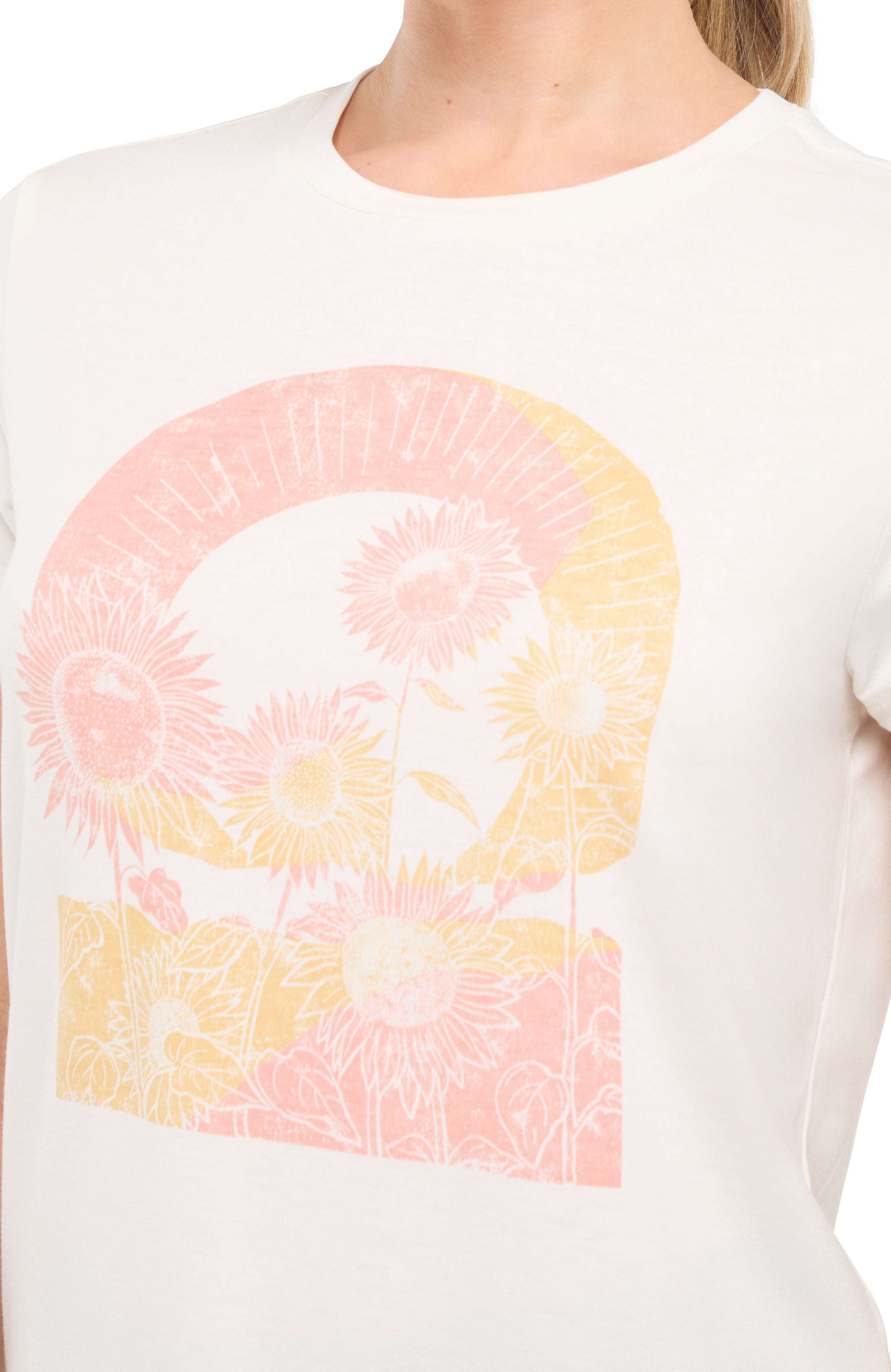 Close up front view of woman wearing a white t-shirt with colorful tie-dye sunflowers graphic on a white background.