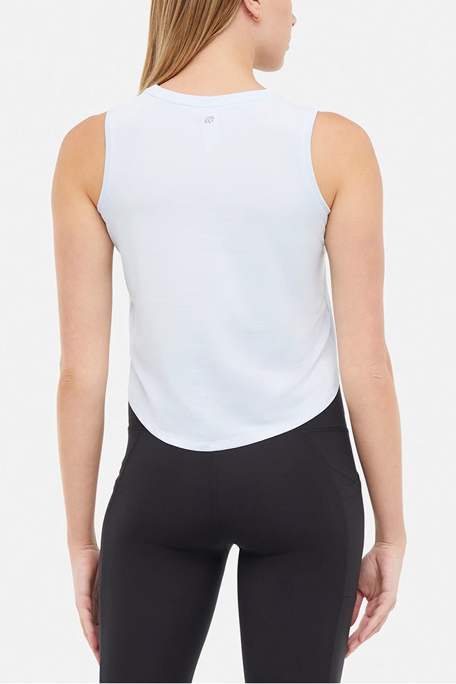 Back view of woman wearing a light blue sleeveless top and black leggings on a light gray background.