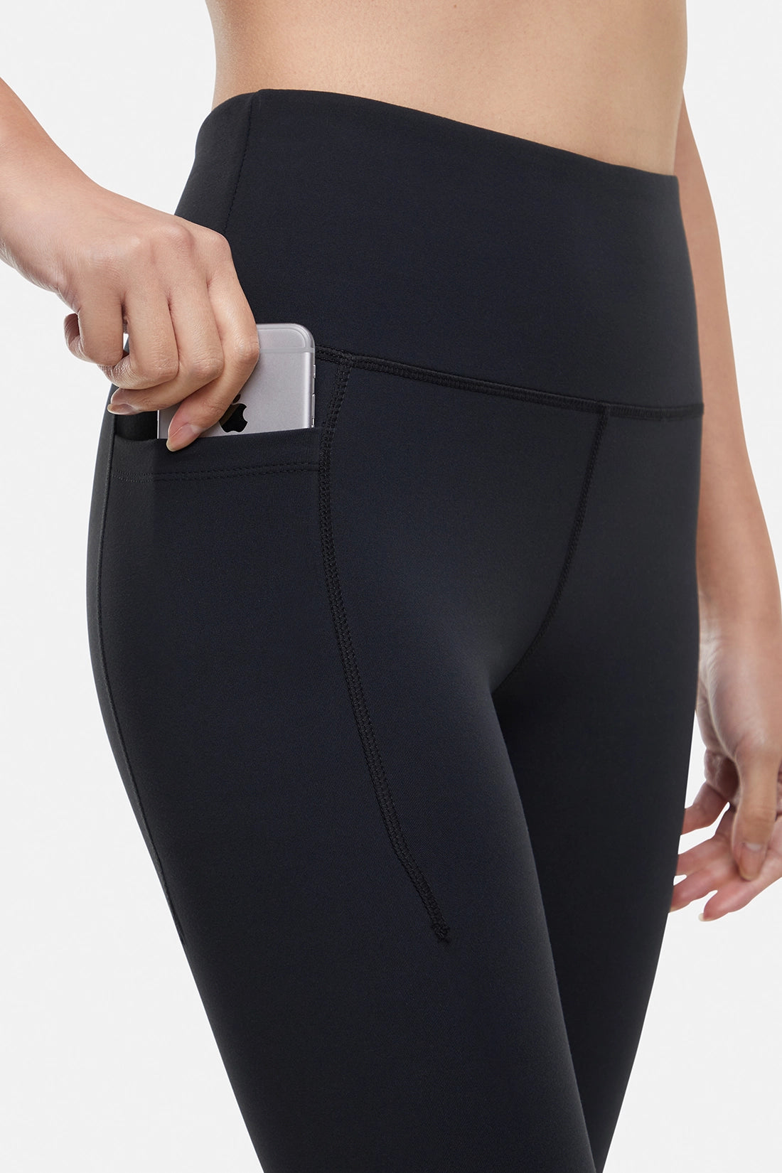 Front close up view of woman wearing black leggings worn by a person on a white background.