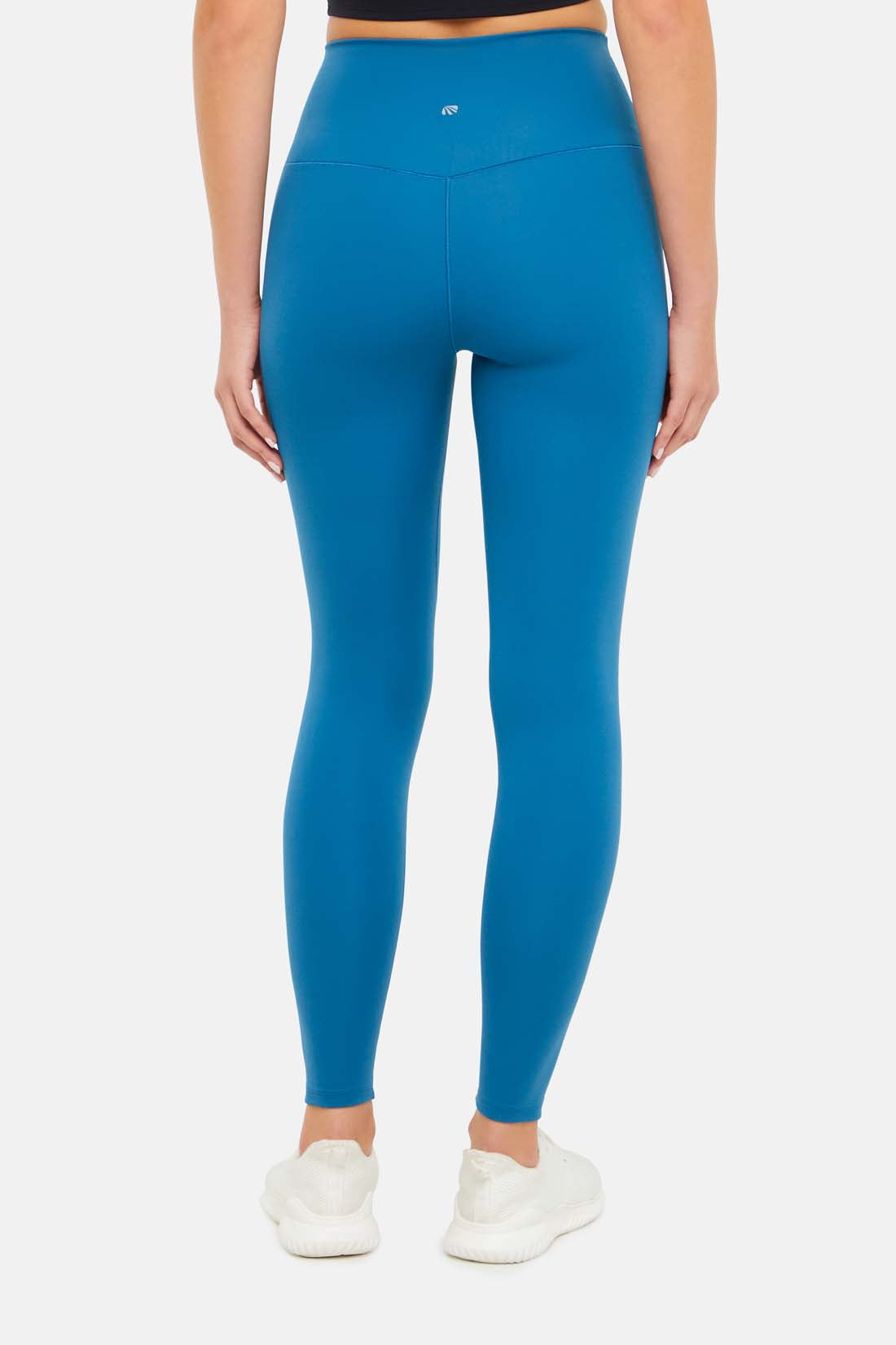 Back view of woman wearing bright blue leggings on a white background.