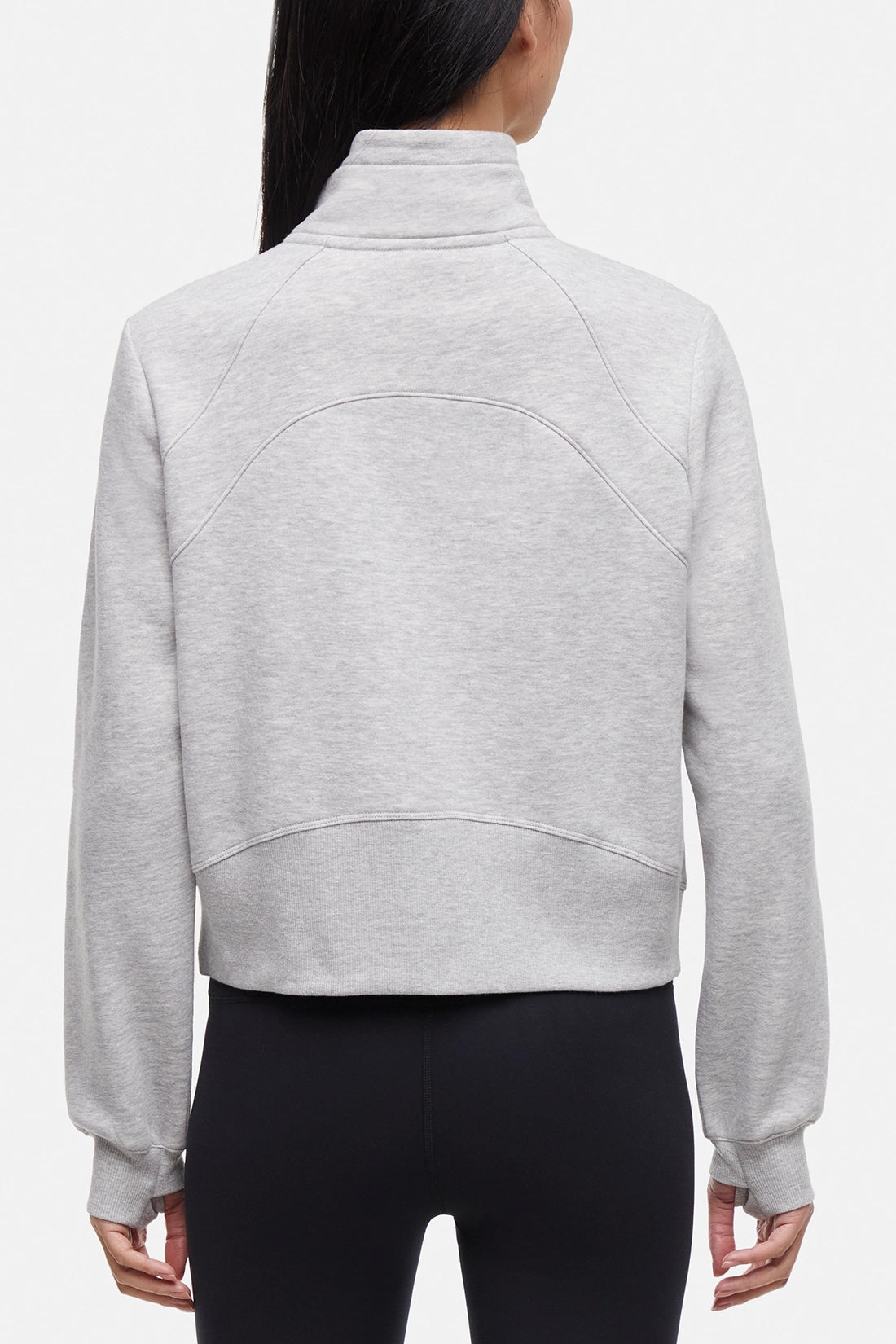 Back view of woman wearing heather gray half-zip pullover with thumbholes on a white background.