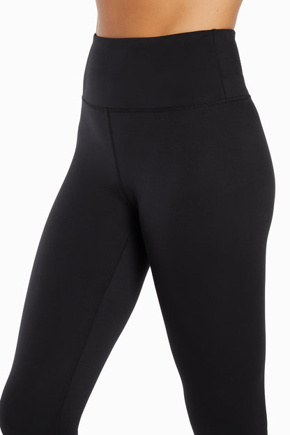 Close up front view of woman wearing black leggings on a white background. 