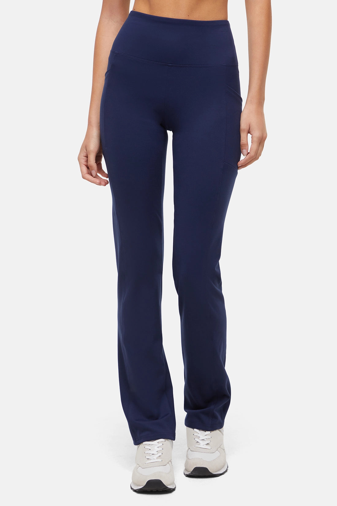 Navy blue leggings worn by a person on a white background. 