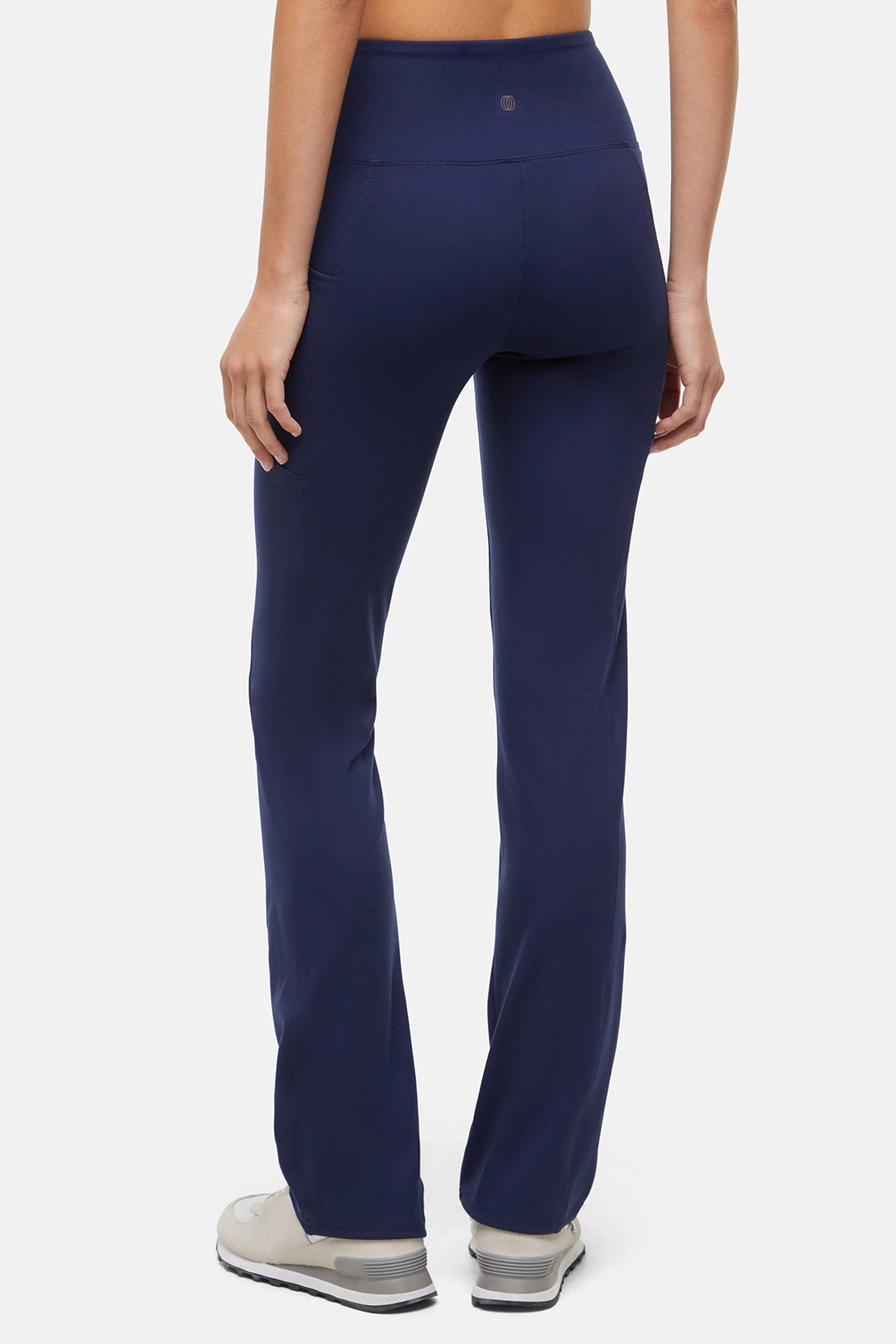 Navy blue pants worn by a person on a white background. 