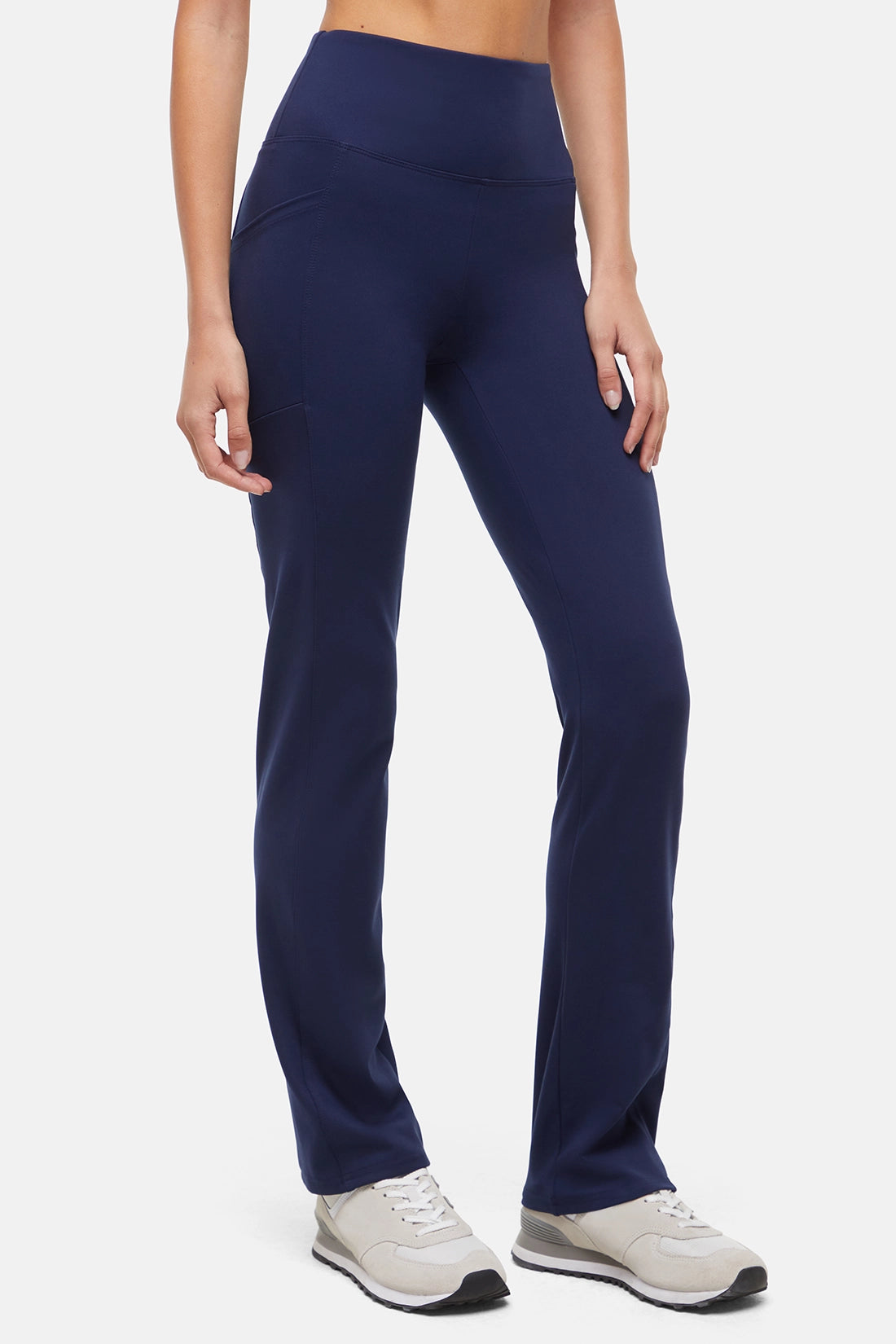 Person wearing navy blue leggings on a white background. 