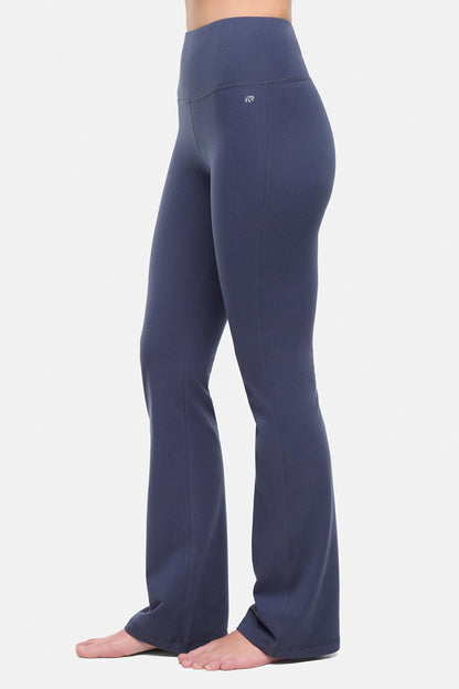 Side view of woman wearing navy blue yoga pants on a white background. 
