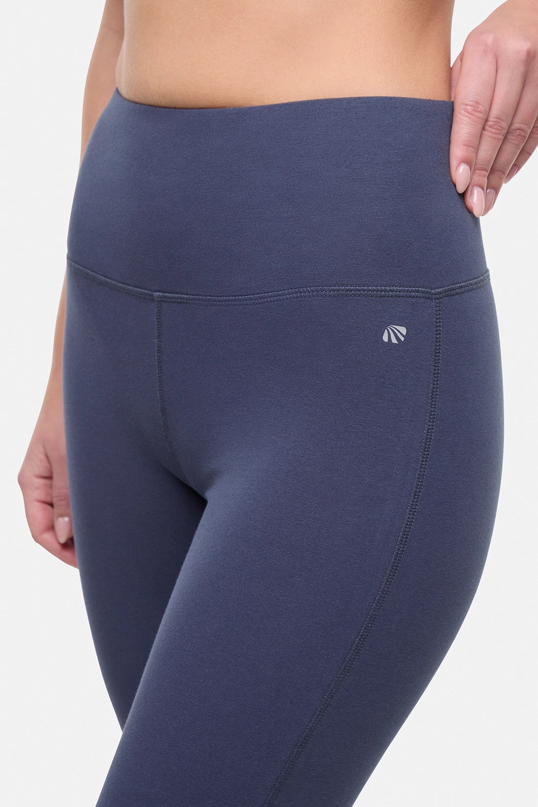 Close up front view of woman wearing navy blue yoga pants on a white background. 