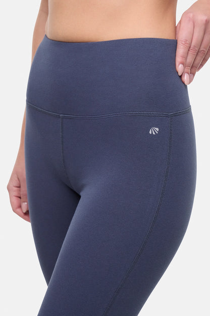 Close up front view of woman wearing navy blue yoga pants on a white background. 