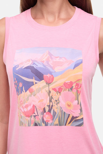 Close up view of woman wearing a pink sleeveless top with a colorful floral and mountain design on a white background.