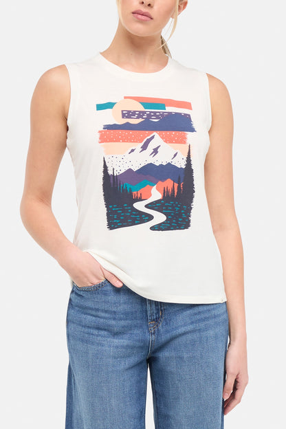 Front view of woman wearing a sleeveless shirt with a mountain graphic design on a plain background. 