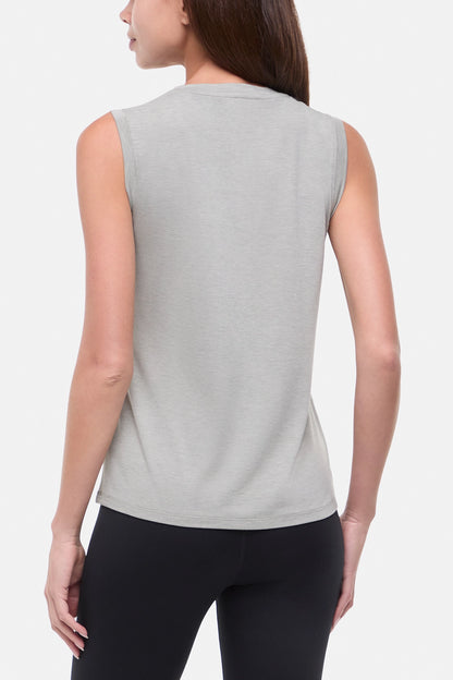 Back view of woman wearing a sleeveless gray top with colorful floral and cactus design on a white background. 