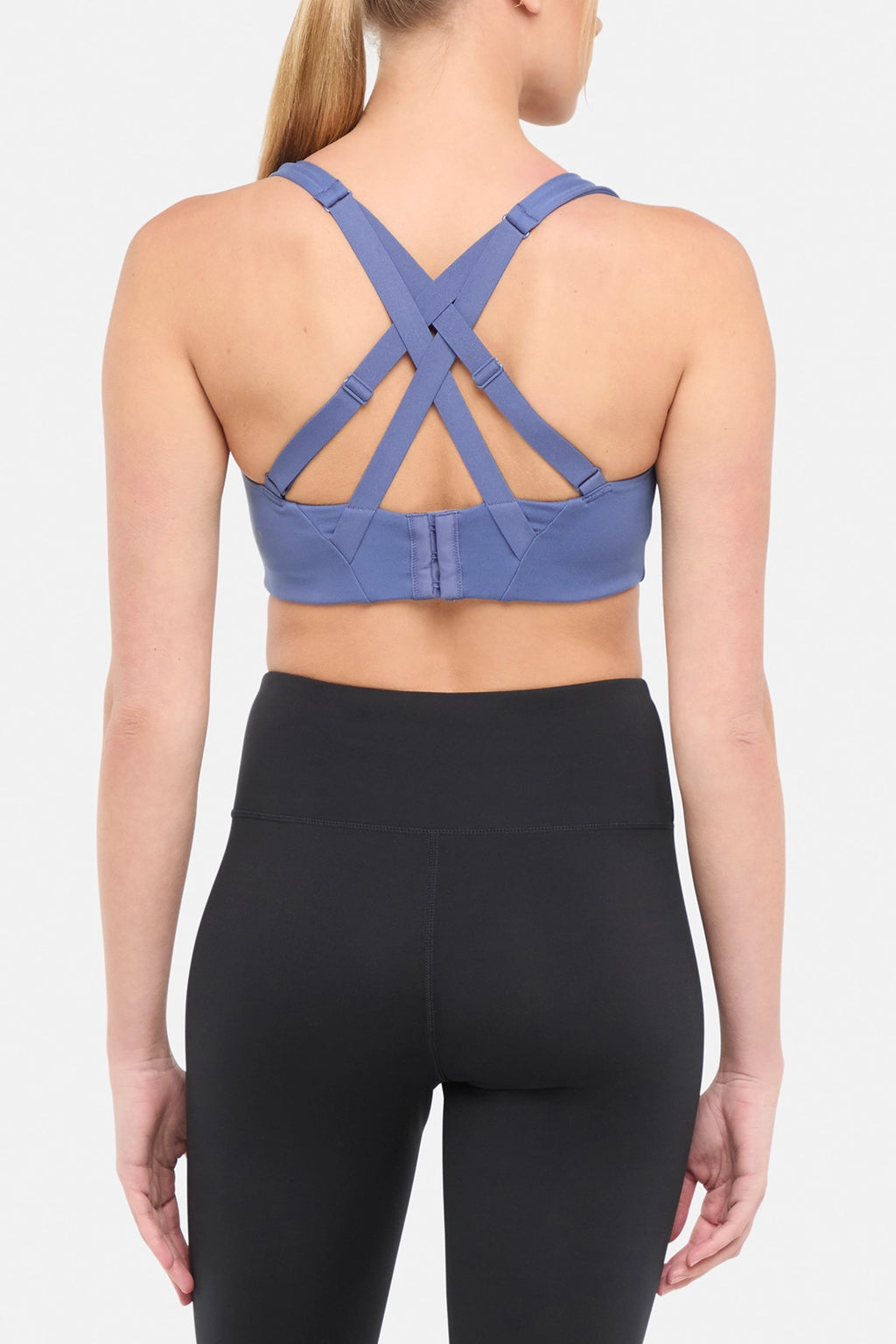 Back view of blue sports bra with strappy crisscross straps on a plain background. #color_gray-blue