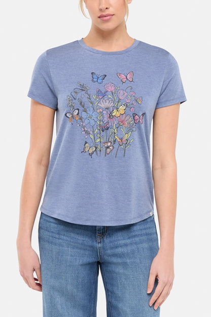 Front view of woman wearing a blue t-shirt with butterflies and floral design on a white background. 