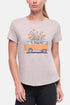 Front view of woman wearing a beige t-shirt with a graphic of an orange van and flowers on a .white background. 