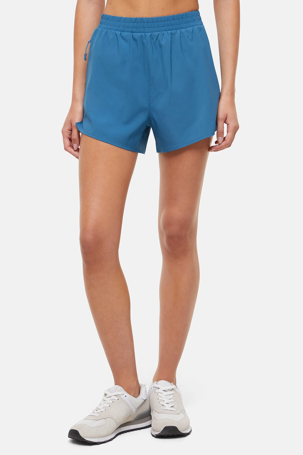 Front view of woman wearing blue shorts on a white background. #color_midnight