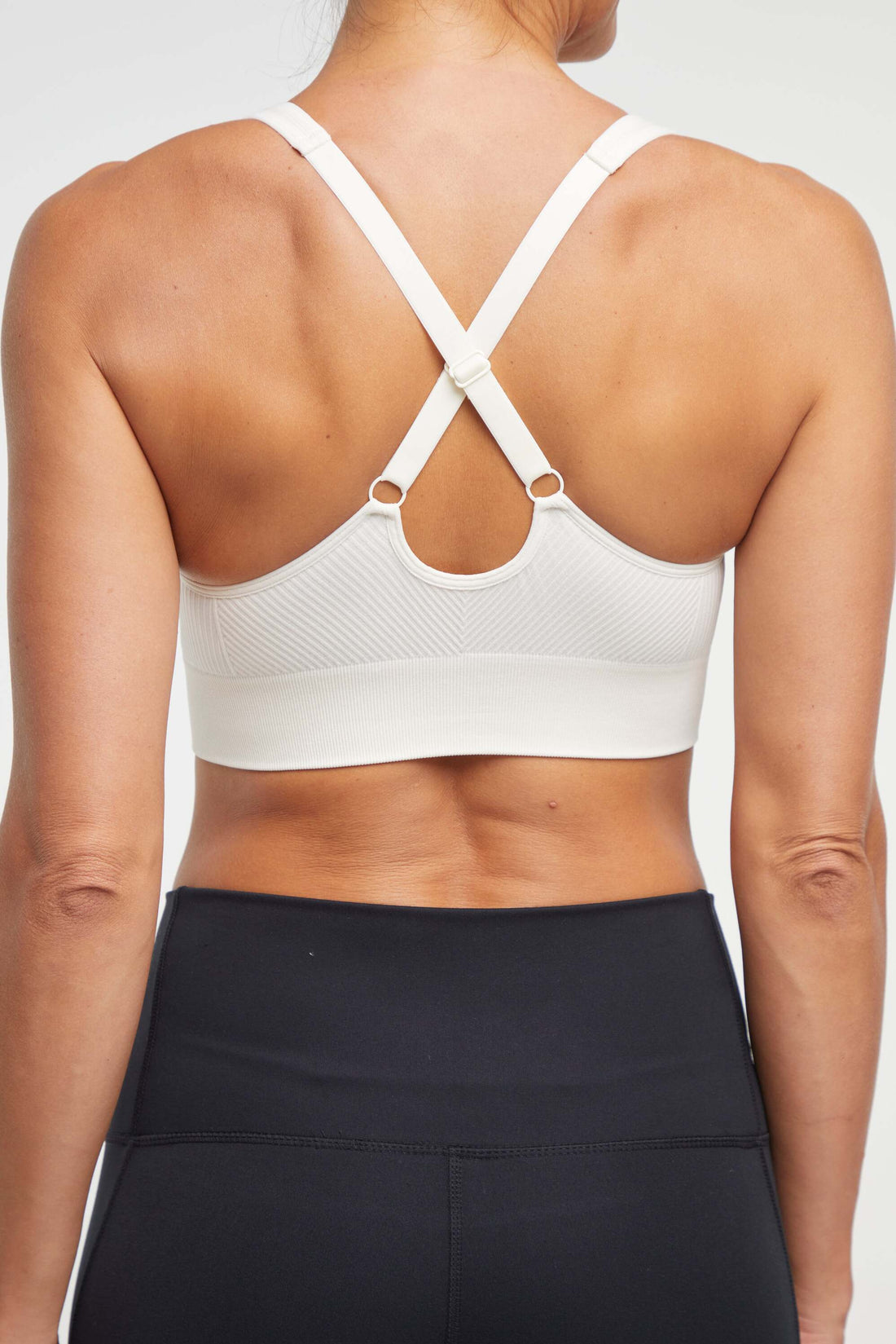Addie Seamless Sports Bra, side view showing pocket placement, showing visible design features and texture of the soft knit fabric.. 