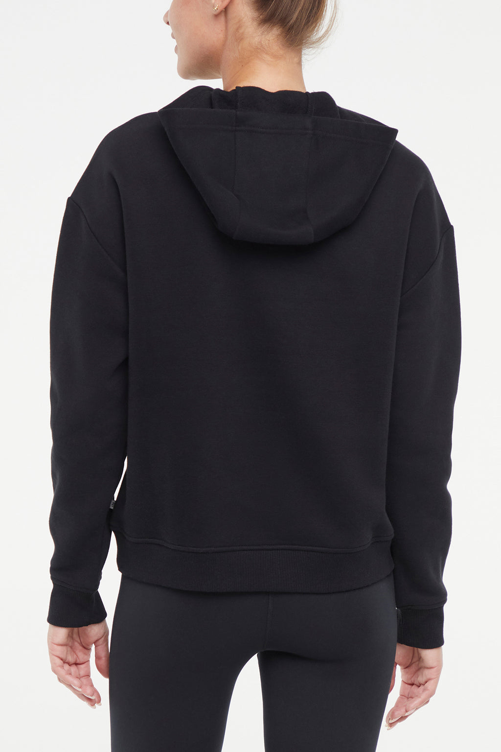 Camila Hoodie, side view showing pocket placement, showing visible design features and texture of the soft fleece fabric.. #color_black