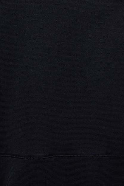 A close-up of a black ribbed fabric texture with a horizontal seam near the bottom. 