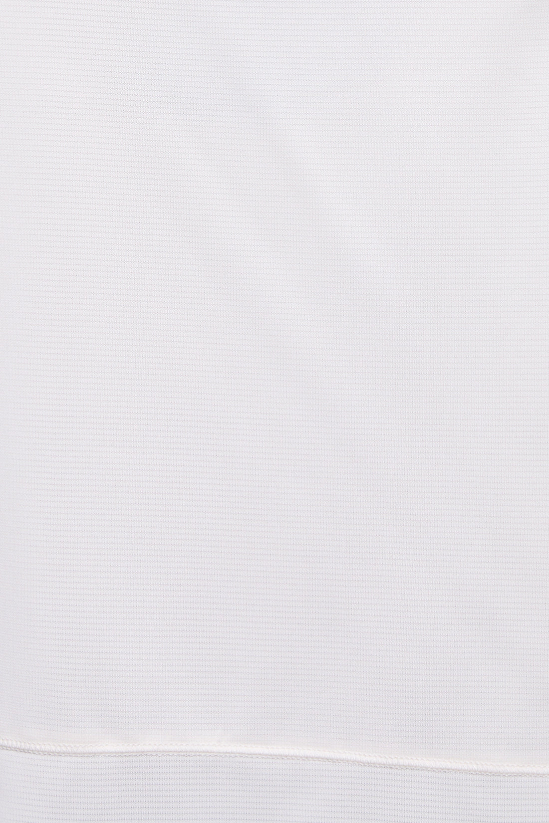 A close-up of a white ribbed knit fabric, showing the fine texture and a horizontal seam near the bottom edge.  