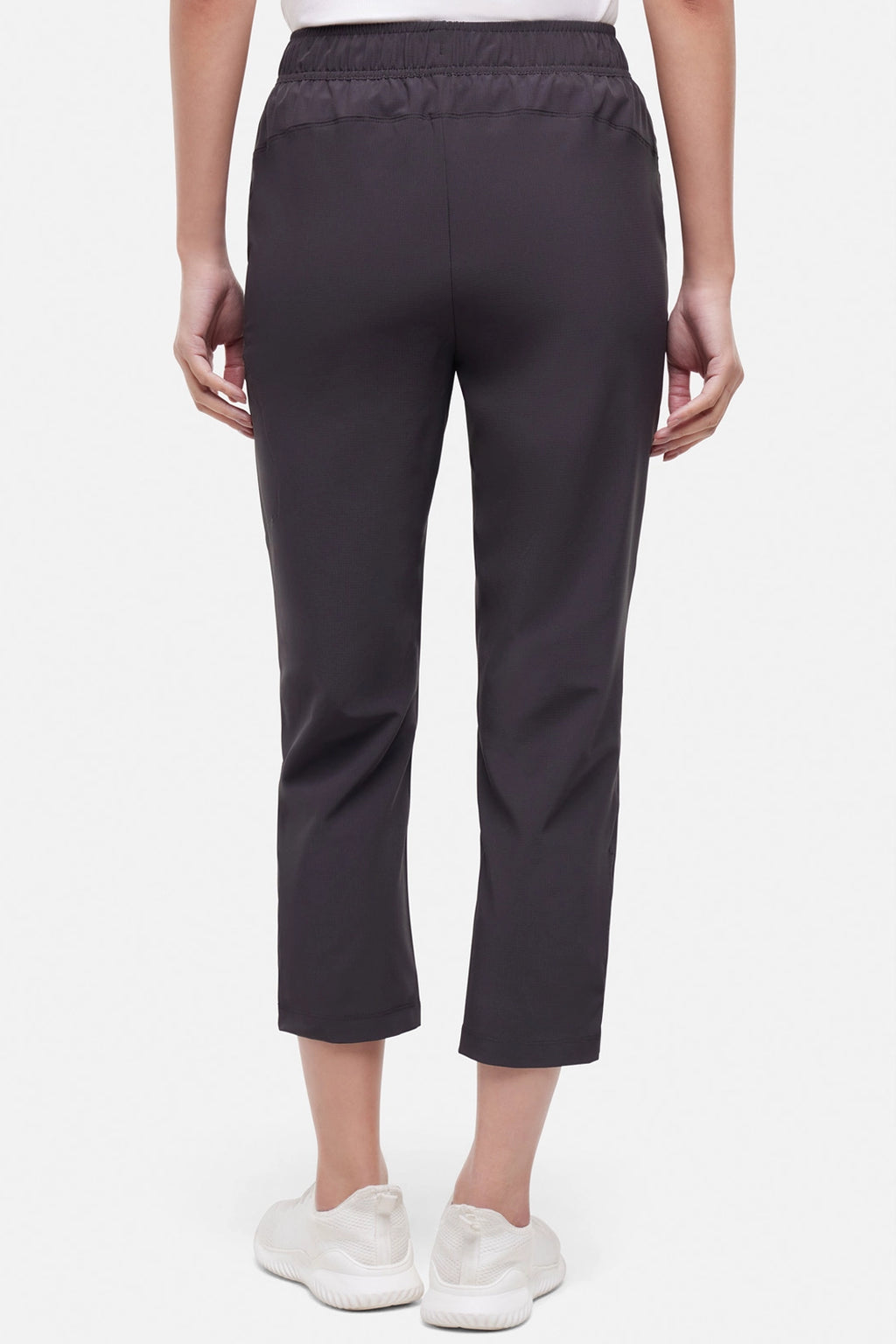 Back view of woman wearing black cropped pants with a white drawstring on a white background. #color_phantom