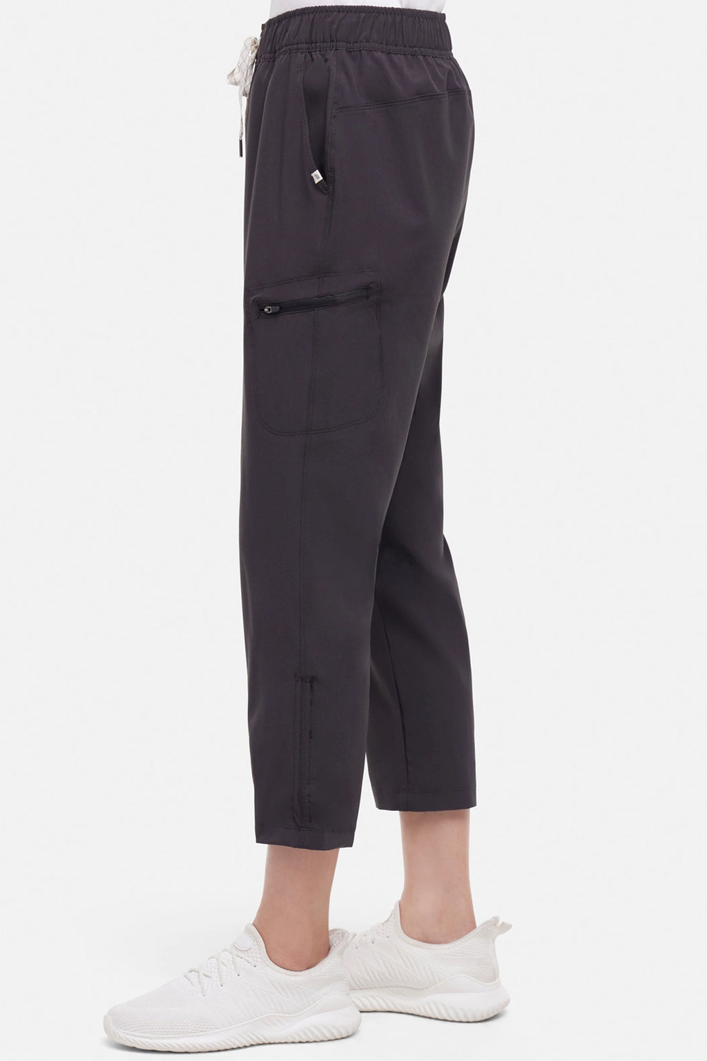 Side view of woman wearing black cropped pants with a white drawstring on a white background. #color_phantom
