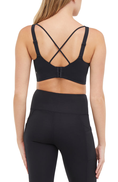 Back view of woman wearing a black sports bra and matching black leggings on a white background. #color_black