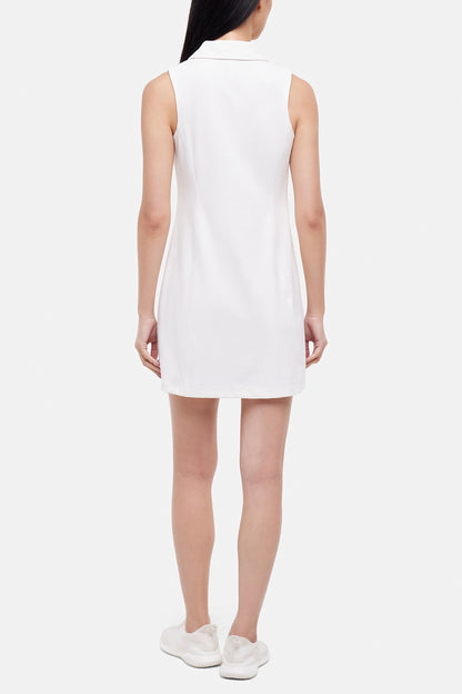 Back view of woman wearing a white sleeveless polo dress with a black stripe collar on a white background. 