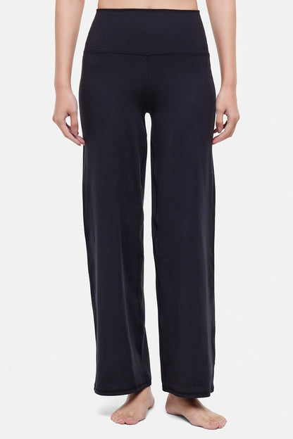 Front view of woman wearing black yoga pants on a white background. 