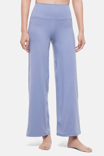 Front view of woman wearing light blue pants on a white background. 