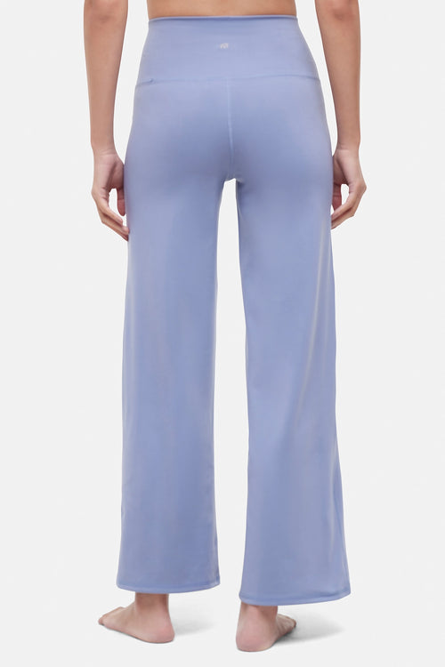 Back view of woman wearing light blue pants on a white background. #color_troposphere