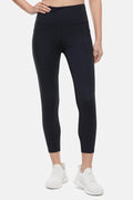 Front view of woman wearing black leggings worn by a person on a white background. #color_black