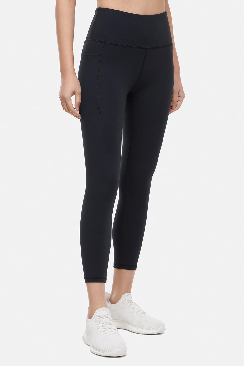 Front view of woman wearing black leggings worn by a person on a white background. #color_black