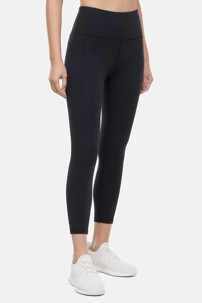 Front view of woman wearing black leggings worn by a person on a white background. 