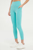 Front view of woman wearing light turquoise leggings worn by a person on a white background. 