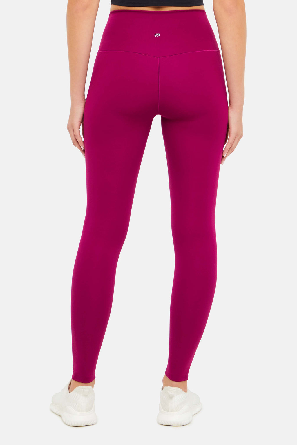 Back view of woman wearing bright burgundy leggings on a white background. #color_magenta-purple