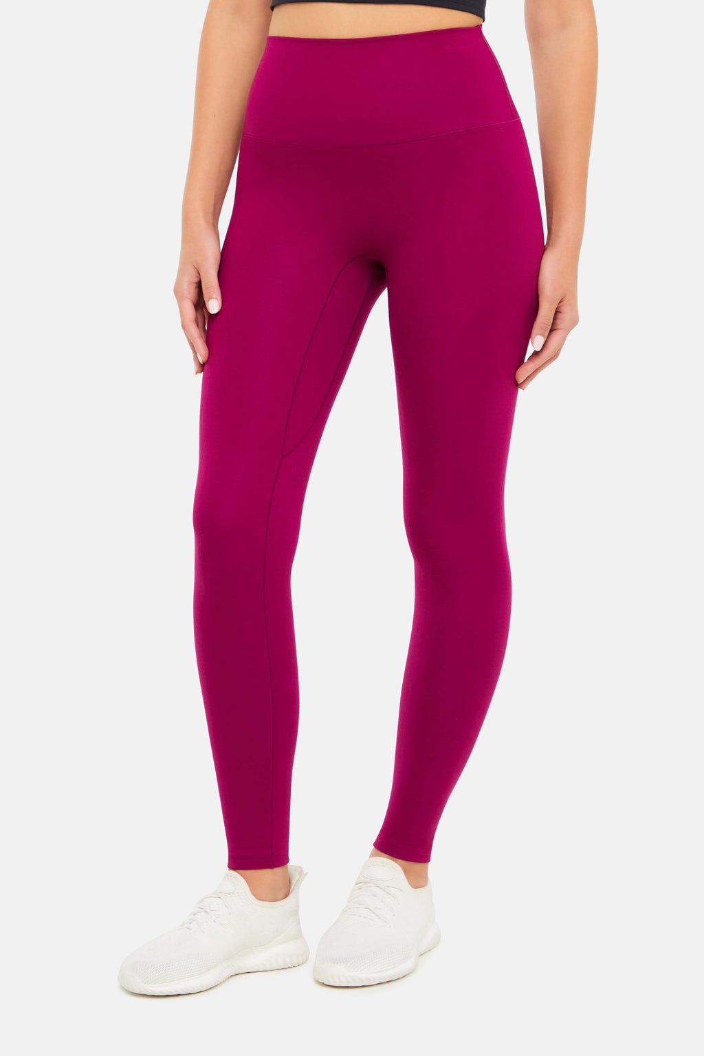 Front view of woman wearing bright burgundy leggings on a white background. #color_magenta-purple