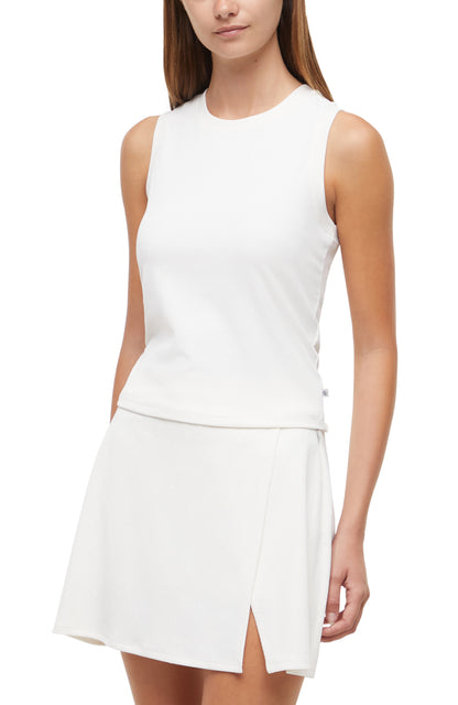 Front view of woman wearing a white sleeveless top and skirt set on a white background. 