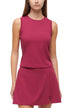 Front view of woman wearing a magenta sleeveless top and skirt set on a white background. 