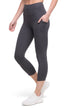 Front of woman wearing dark gray leggings with a white background. 