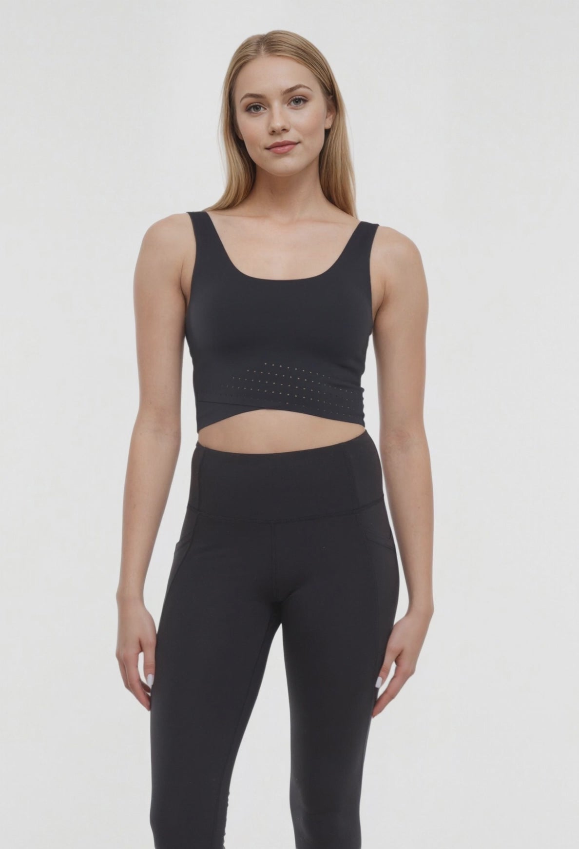 Video view of woman wearing a black sports bra and black leggings on a white background. #color_black