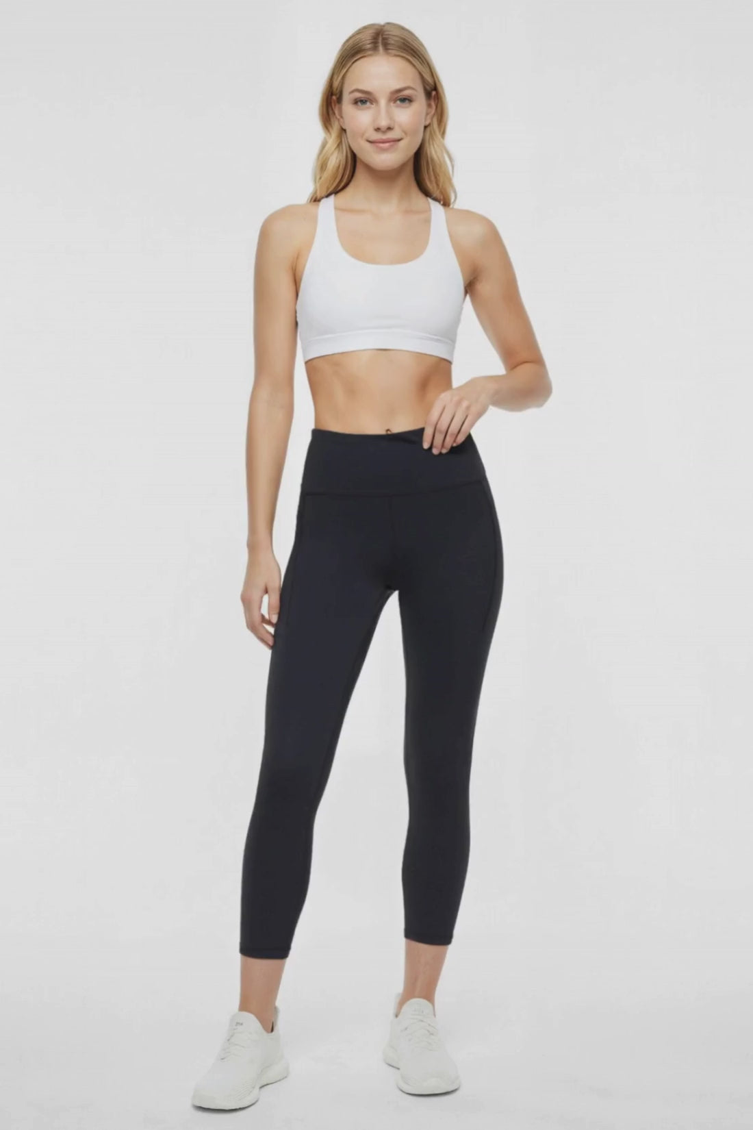 Video view of woman wearing black leggings worn by a person on a white background. 