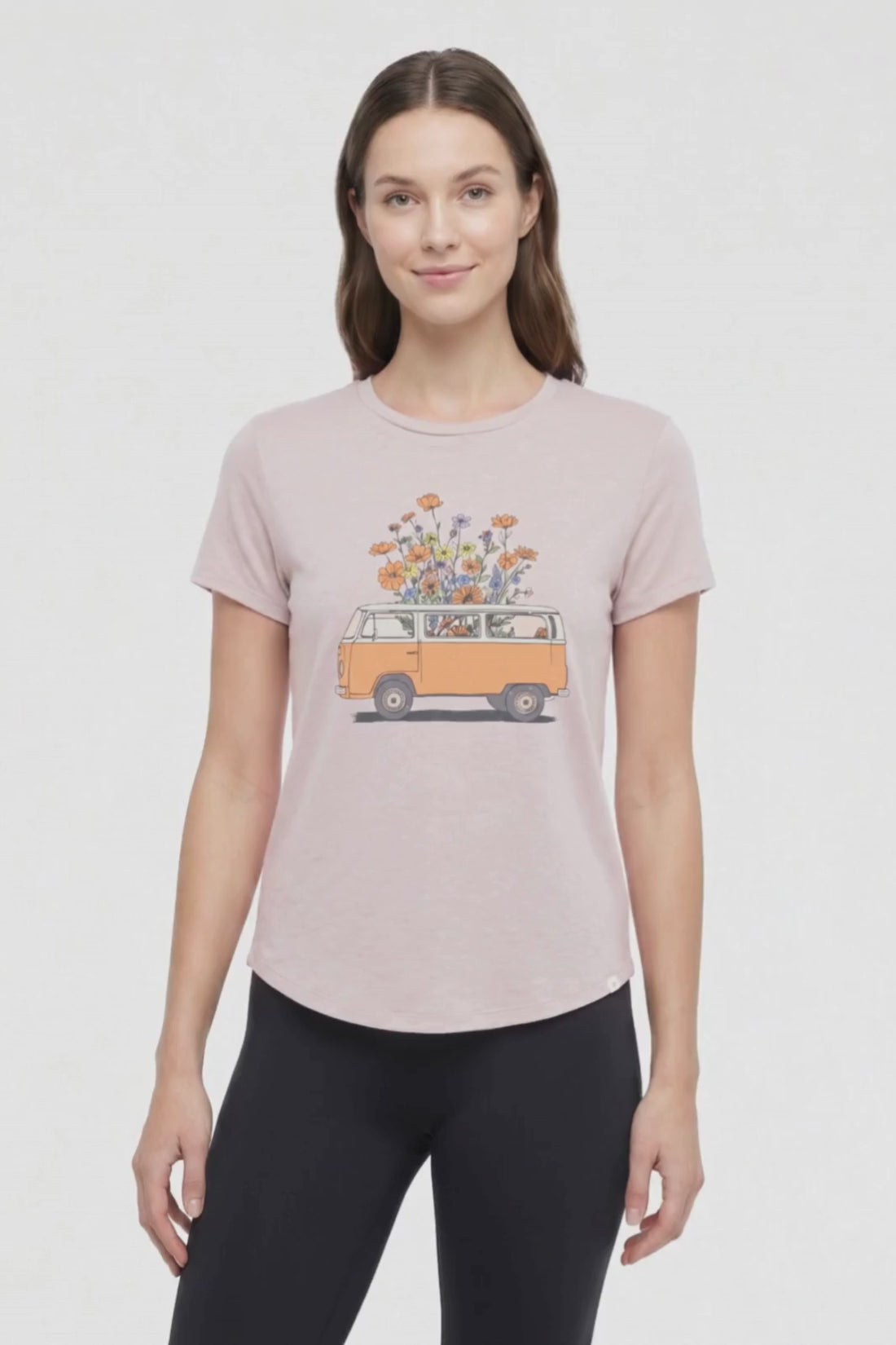 Video view of woman wearing a beige t-shirt with a graphic of an orange van and flowers on a .white background. #color_heather-atmosphere-floral-van-life