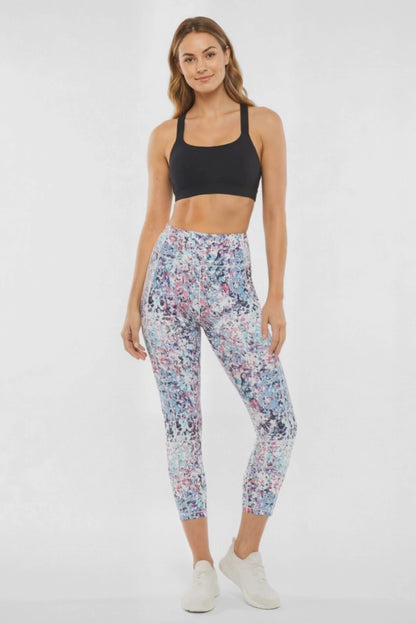 Video view of woman wearing colorful floral leggings on a white background. 