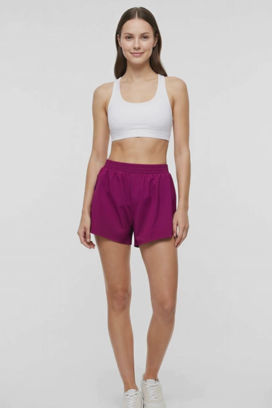 Video view of woman wearing magenta shorts and white bra on a white background. #color_magenta-purple