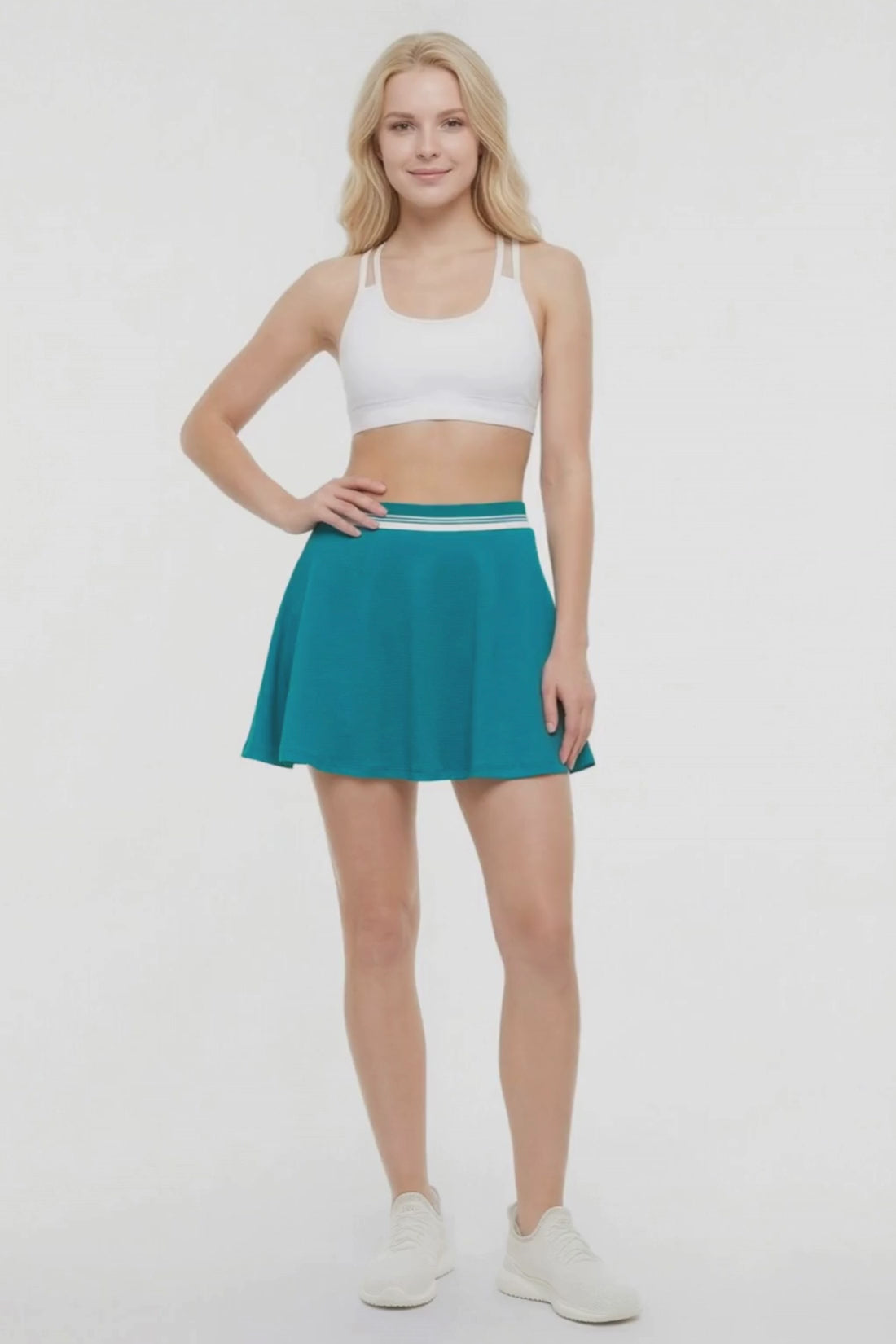 Video view of teal skirt with white stripe waistband worn by a woman on a white background. #color_quetzal-green
