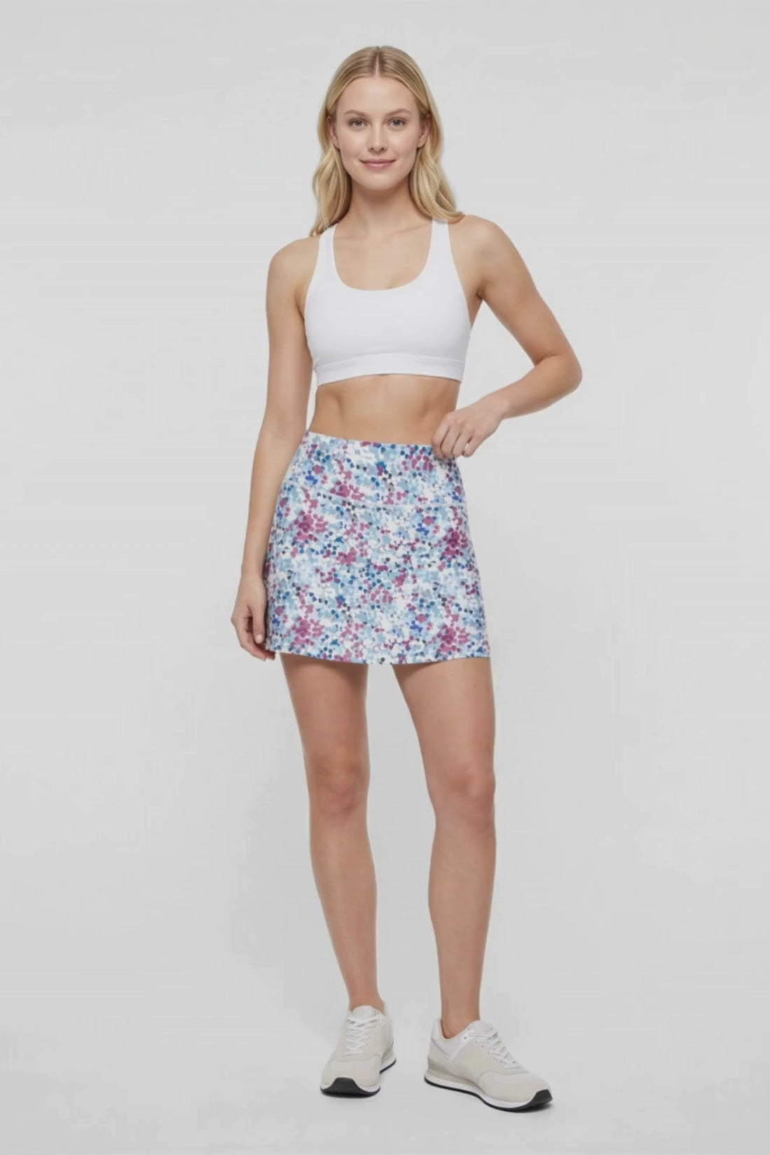 Video view of woman wearing spotted floral patterned skort design on a white background. #color_magenta-purple-kaleidoscope-floral